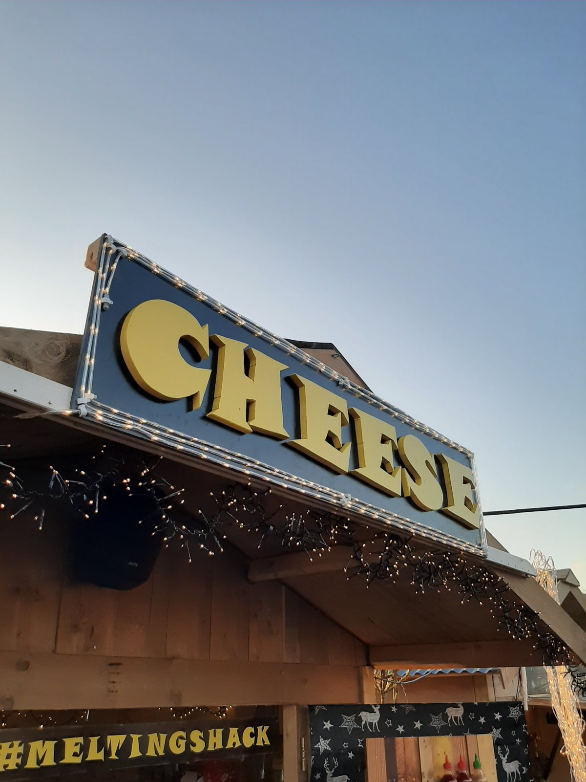 The Cheese sign above the stall strung with lights
